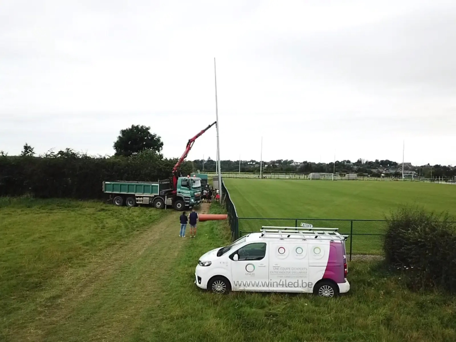 Installation terrain de sport LED – chantier Win4LED avec grue et équipe technique Installation d’un éclairage LED sportif sur terrain de football – Win4LED en action
